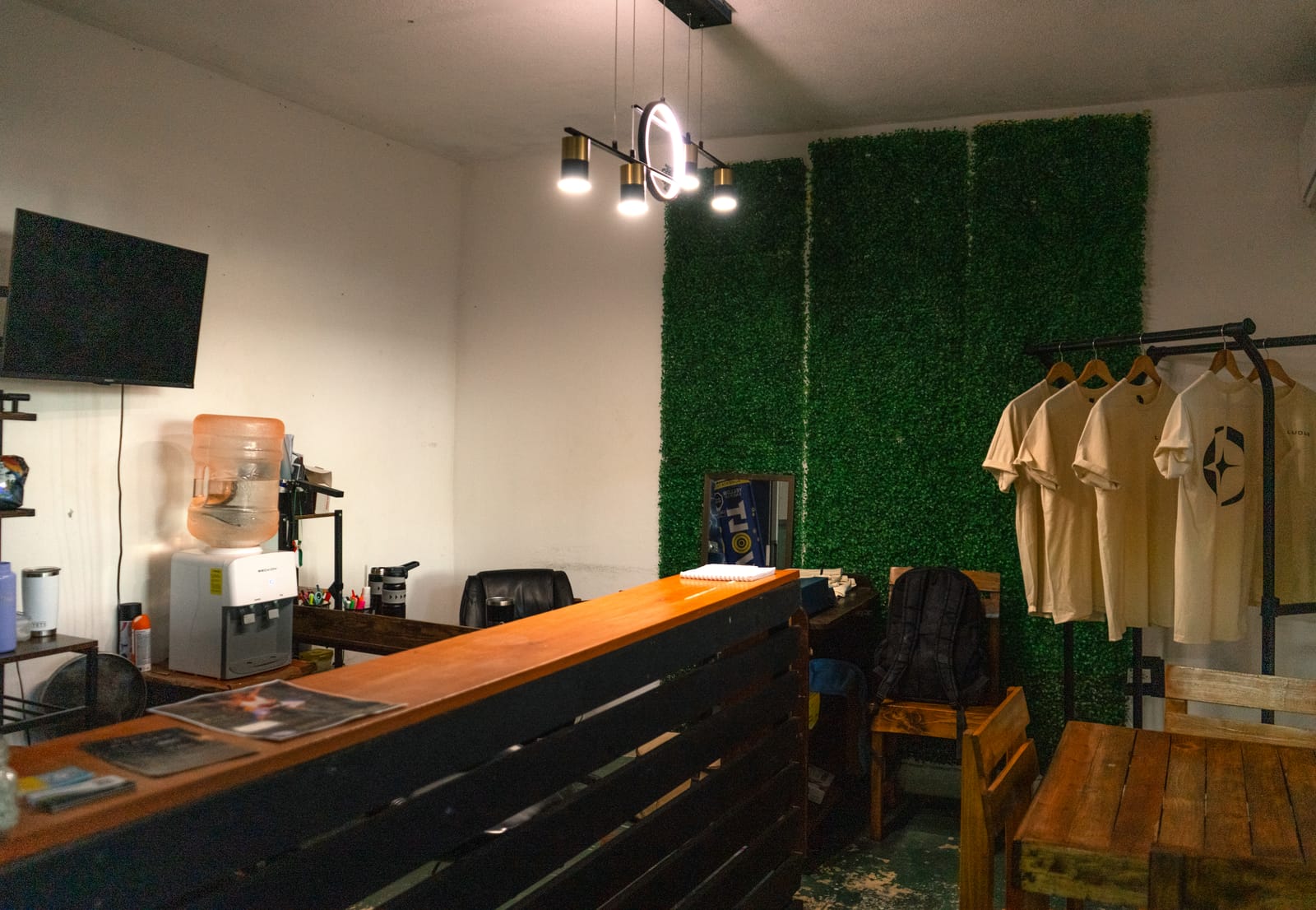Recepción de LUDUS TRAINING CENTER con muro verde y merchandising